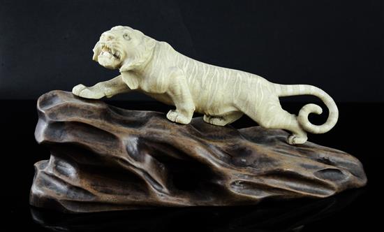 A Japanese ivory figure of a prowling tiger, Meiji period, length 26cm incl. carved wood stand